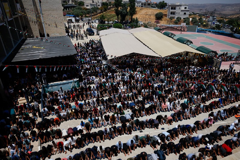 Orang-orang membawa jenazah Sayfollah Kamel Musallet, seorang pria Palestina-Amerika yang dipukuli hingga tewas oleh para pemukim, menurut Kementerian Kesehatan Palestina, dalam pemakamannya di dekat Ramallah, di Tepi Barat yang diduduki Israel, 13 Juli 2025. REUTERS/Ammar Awad