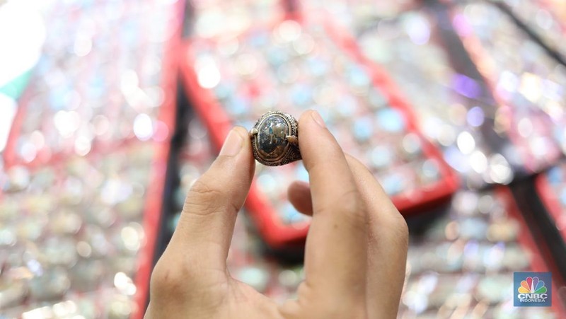 Pedagang memasarkan batu cicin secara daring di Pasar Rawa Bening, Jakarta, Senin (14/7/2025).  (CNBC Indonesia/Tri Susilo)