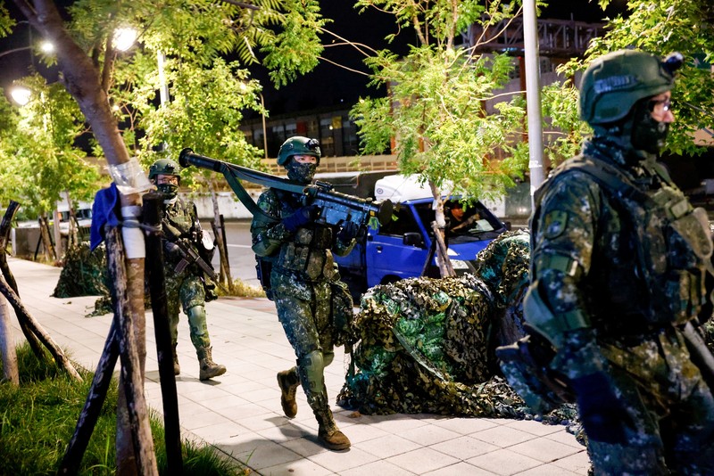 Seorang pria menunggu untuk menyeberang jalan saat kendaraan lapis baja CM-34 Clouded Leopard ikut serta dalam latihan simulasi serangan China, di daerah perkotaan sebagai bagian dari latihan tahunan Han Kuang, di Kota Taipei Baru, Taiwan, 15 Juli 2025. Seorang pria menunggu untuk menyeberang jalan saat kendaraan lapis baja CM-34 Clouded Leopard ikut serta dalam latihan simulasi serangan China, di daerah perkotaan sebagai bagian dari latihan tahunan Han Kuang, di Kota Taipei Baru, Taiwan, 15 Juli 2025. (REUTERS/Annabelle Chih)