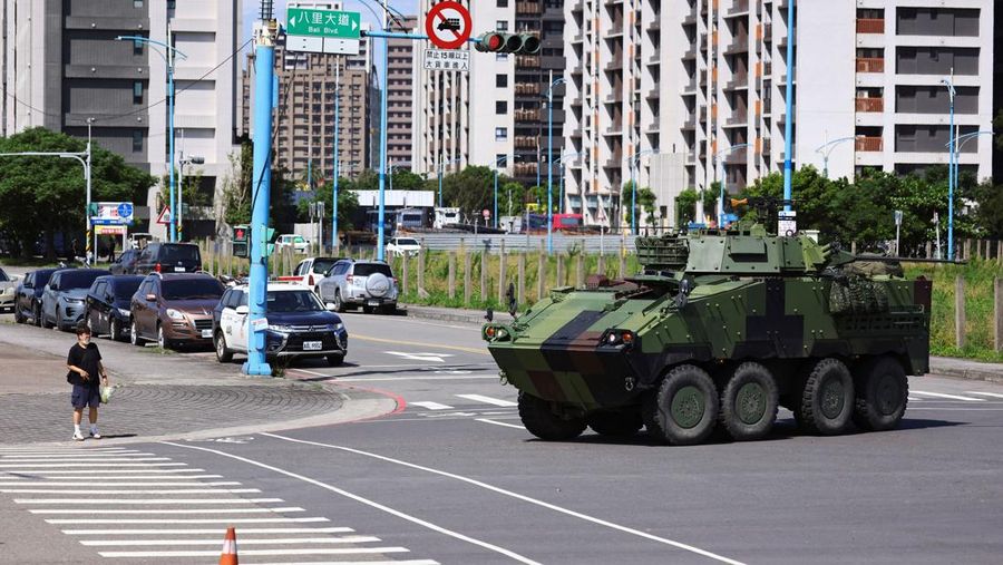 Seorang pria menunggu untuk menyeberang jalan saat kendaraan lapis baja CM-34 Clouded Leopard ikut serta dalam latihan simulasi serangan China, di daerah perkotaan sebagai bagian dari latihan tahunan Han Kuang, di Kota Taipei Baru, Taiwan, 15 Juli 2025. Seorang pria menunggu untuk menyeberang jalan saat kendaraan lapis baja CM-34 Clouded Leopard ikut serta dalam latihan simulasi serangan China, di daerah perkotaan sebagai bagian dari latihan tahunan Han Kuang, di Kota Taipei Baru, Taiwan, 15 Juli 2025. (REUTERS/Annabelle Chih)