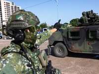 Seorang tentara memberi isyarat di dekat kendaraan lapis baja selama latihan simulasi serangan Tiongkok, di daerah perkotaan sebagai bagian dari latihan tahunan Han Kuang, di Kota Taipei Baru, Taiwan, 15 Juli 2025. (REUTERS/Annabelle Chih)
