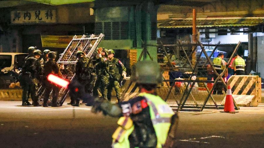 Seorang pria menunggu untuk menyeberang jalan saat kendaraan lapis baja CM-34 Clouded Leopard ikut serta dalam latihan simulasi serangan China, di daerah perkotaan sebagai bagian dari latihan tahunan Han Kuang, di Kota Taipei Baru, Taiwan, 15 Juli 2025. (REUTERS/Annabelle Chih)