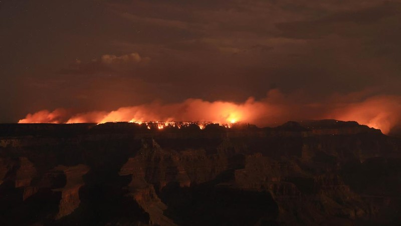 Smoke from the Dragon Bravo Fire colors a setting sun for onlookers at Grandeur Point on the southern rim of Grand Canyon, Arizona, U.S. July 14, 2025.  REUTERS/David Swanson     TPX IMAGES OF THE DAY