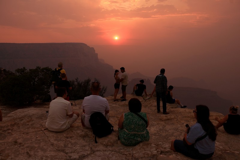 Smoke from the Dragon Bravo Fire colors a setting sun for onlookers at Grandeur Point on the southern rim of Grand Canyon, Arizona, U.S. July 14, 2025.  REUTERS/David Swanson     TPX IMAGES OF THE DAY