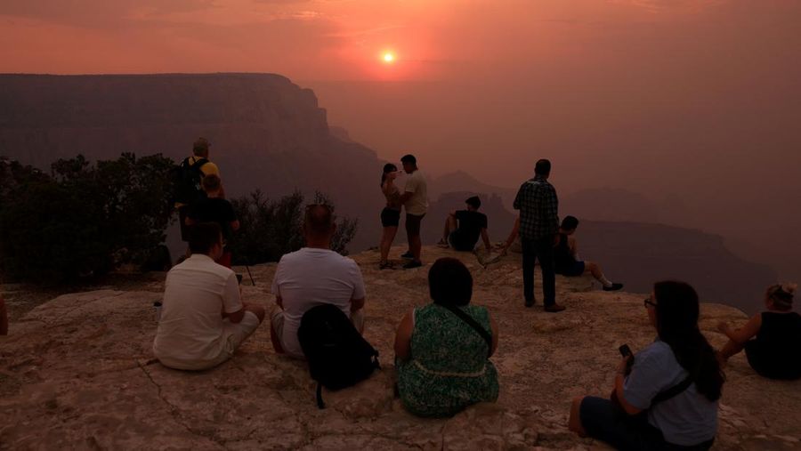 USA-WILDFIRES/GRAND-CANYON Smoke from the Dragon Bravo Fire colors a setting sun for onlookers at Grandeur Point on the southern rim of Grand Canyon, Arizona, U.S. July 14, 2025. REUTERS/David Swanson TPX IMAGES OF THE DAY