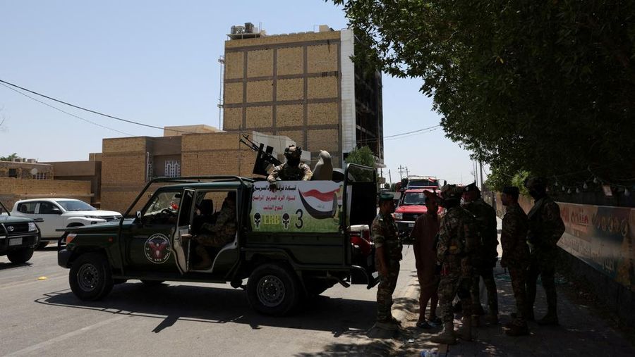 Truk pemadam kebakaran berdiri di samping reruntuhan pusat perbelanjaan, setelah kebakaran besar semalam yang menewaskan puluhan orang, di al-Kut, provinsi Wasit, Irak, 17 Juli 2025. (REUTERS/Ahmed Saad)