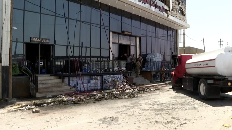 Truk pemadam kebakaran berdiri di samping reruntuhan pusat perbelanjaan, setelah kebakaran besar semalam yang menewaskan puluhan orang, di al-Kut, provinsi Wasit, Irak, 17 Juli 2025. (REUTERS/Ahmed Saad)