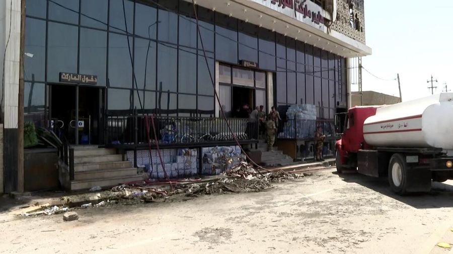 Truk pemadam kebakaran berdiri di samping reruntuhan pusat perbelanjaan, setelah kebakaran besar semalam yang menewaskan puluhan orang, di al-Kut, provinsi Wasit, Irak, 17 Juli 2025. (REUTERS/Ahmed Saad)