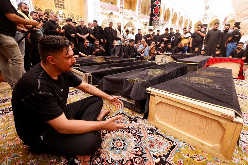 Truk pemadam kebakaran berdiri di samping reruntuhan pusat perbelanjaan, setelah kebakaran besar semalam yang menewaskan puluhan orang, di al-Kut, provinsi Wasit, Irak, 17 Juli 2025. (REUTERS/Ahmed Saad)