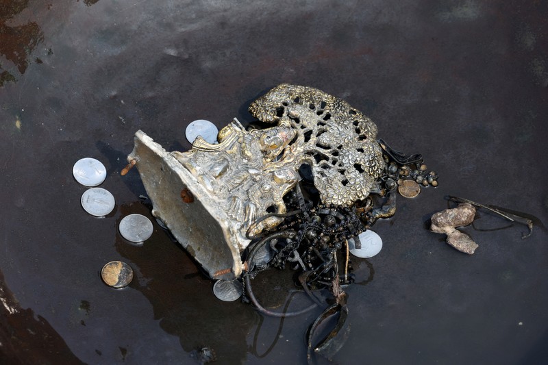 Ramu Gupta, seorang pria berusia 67 tahun yang pergi ke sungai untuk berburu koin dan barang berharga lainnya, mengeluarkan tas berisi plastik dari perairan sungai Yamuna di New Delhi, India, 26 Juni 2025. (REUTERS/Bhawika Chhabra)