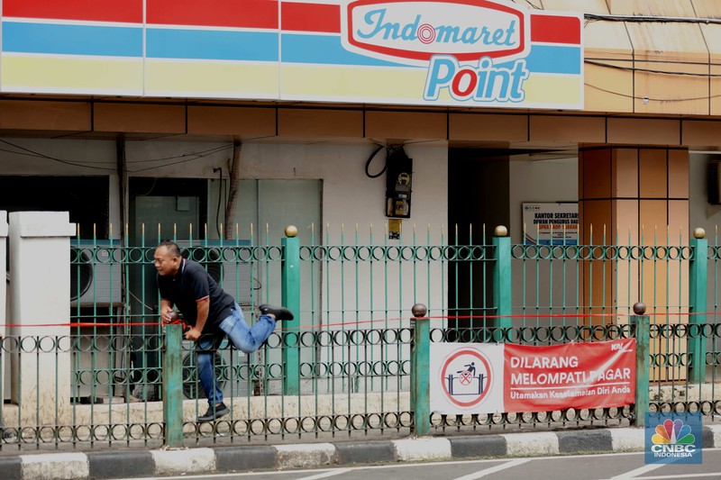 penumpang krl, commuterline, kai, Sejumlah warga calon penumpang commuterline melompati pagar pembatas antara jalan dan Stasiun Cikini di Jakarta, Jumat (18/7/2025). (CNBC Indonesia/Tri Susilo)