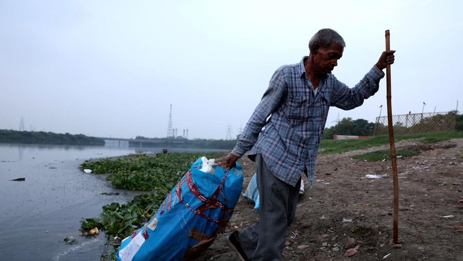 Ramu Gupta, seorang pria berusia 67 tahun yang pergi ke sungai untuk berburu koin dan barang berharga lainnya, mengeluarkan tas berisi plastik dari perairan sungai Yamuna di New Delhi, India, 26 Juni 2025. Ramu Gupta, seorang pria berusia 67 tahun yang pergi ke sungai untuk berburu koin dan barang berharga lainnya, mengeluarkan tas berisi plastik dari perairan sungai Yamuna di New Delhi, India, 26 Juni 2025. (REUTERS/Bhawika Chhabra)