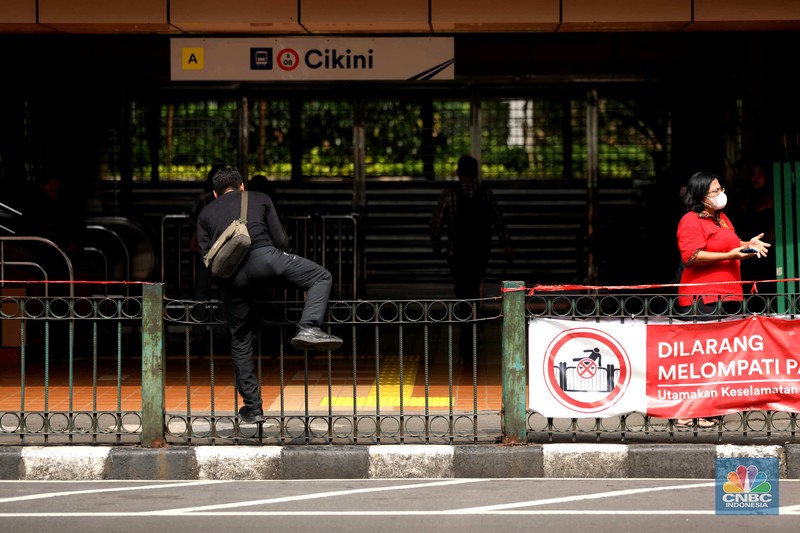 Sejumlah warga calon penumpang commuterline melompati pagar pembatas antara jalan dan Stasiun Cikini di Jakarta, Jumat (18/7/2025). Sejumlah warga calon penumpang commuterline melompati pagar pembatas antara jalan dan Stasiun Cikini di Jakarta, Jumat (18/7/2025). (CNBC Indonesia/Tri Susilo)