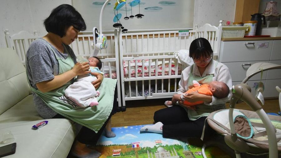 Pekerja sosial merawat bayi di Gereja Komunitas Jusarang di Seoul selatan. Korea Selatan akan merombak sistem adopsinya pada 19 Juli 2025, dengan mengakhiri praktik adopsi alih daya yang telah berlangsung selama puluhan tahun. (AFP/Jung Yeon-je/File)