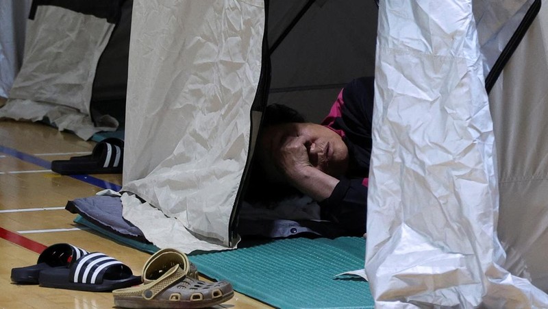 Warga yang dievakuasi dari desa-desa yang rusak akibat hujan deras, beristirahat di tempat penampungan sementara, di Yesan, Korea Selatan. (REUTERS/Kim Hong-Ji)