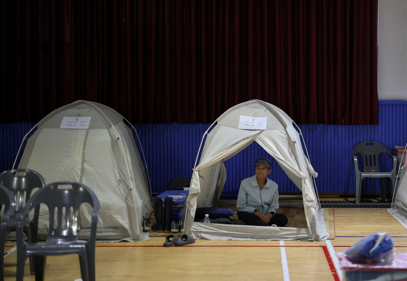 Warga yang dievakuasi dari desa-desa yang rusak akibat hujan deras, beristirahat di tempat penampungan sementara, di Yesan, Korea Selatan. (REUTERS/Kim Hong-Ji)