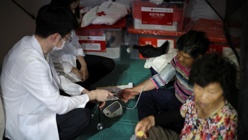 Warga yang dievakuasi dari desa-desa yang rusak akibat hujan deras, beristirahat di tempat penampungan sementara, di Yesan, Korea Selatan. (REUTERS/Kim Hong-Ji)