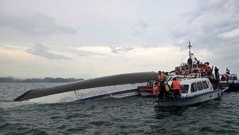 Sebuah kapal yang membawa wisatawan di sekitar Teluk Ha Long, Vietnam, terbalik akibat badai. Media pemerintah melaporkan sebanyak 34 orang ditanyakan tewas. Minggu (20/7/2025). (AFP/NHAC NGUYEN)