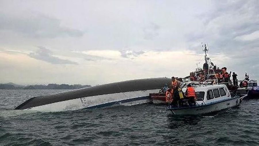 Sebuah kapal yang membawa wisatawan di sekitar Teluk Ha Long, Vietnam, terbalik akibat badai. Media pemerintah melaporkan sebanyak 34 orang ditanyakan tewas. Minggu (20/7/2025). (AFP/NHAC NGUYEN)