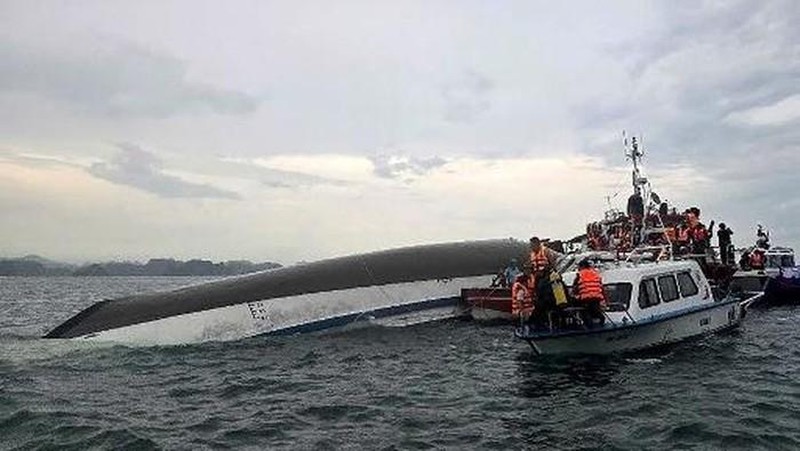 Sebuah kapal yang membawa wisatawan di sekitar Teluk Ha Long, Vietnam, terbalik akibat badai. Media pemerintah melaporkan sebanyak 34 orang ditanyakan tewas. Minggu (20/7/2025). (AFP/NHAC NGUYEN)