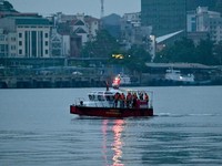 Sebuah kapal yang membawa wisatawan di sekitar Teluk Ha Long, Vietnam, terbalik akibat badai. Media pemerintah melaporkan sebanyak 34 orang ditanyakan tewas. Minggu (20/7/2025). (AFP/NHAC NGUYEN)