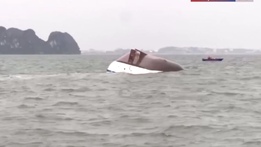 Sebuah kapal yang membawa wisatawan di sekitar Teluk Ha Long, Vietnam, terbalik akibat badai. Media pemerintah melaporkan sebanyak 34 orang ditanyakan tewas. Minggu (20/7/2025). (AFP/NHAC NGUYEN)