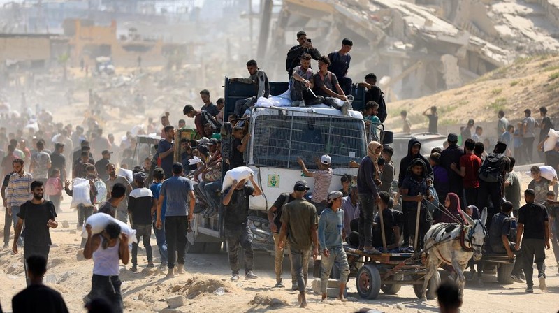 Warga Palestina berkumpul saat membawa pasokan bantuan yang masuk ke Gaza melalui Israel, di tengah krisis kelaparan, di Beit Lahia di Jalur Gaza utara, 20 Juli 2025. (REUTERS/Dawoud Abu Alkas)