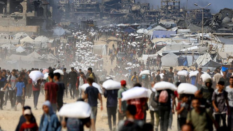 Warga Palestina berkumpul saat membawa pasokan bantuan yang masuk ke Gaza melalui Israel, di tengah krisis kelaparan, di Beit Lahia di Jalur Gaza utara, 20 Juli 2025. (REUTERS/Dawoud Abu Alkas)
