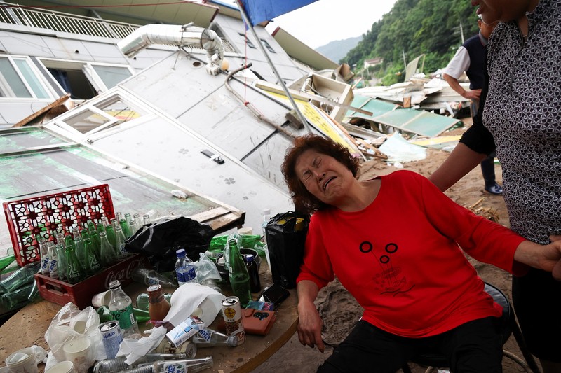 Seorang pria berjalan di depan bangunan yang runtuh akibat hujan deras, di Gapyeong, Korea Selatan, 21 Juli 2025. (REUTERS/Kim Hong-Ji)