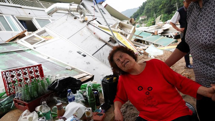 Seorang pria berjalan di depan bangunan yang runtuh akibat hujan deras, di Gapyeong, Korea Selatan, 21 Juli 2025. (REUTERS/Kim Hong-Ji)