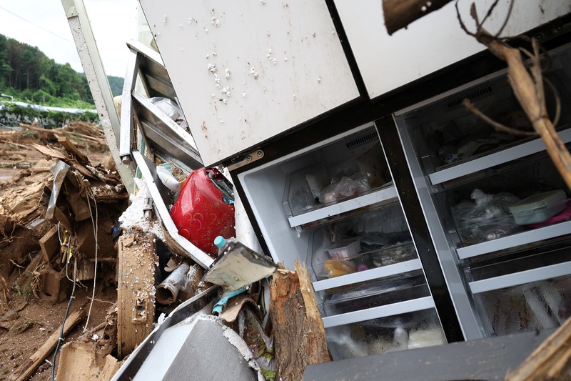 Seorang pria berjalan di depan bangunan yang runtuh akibat hujan deras, di Gapyeong, Korea Selatan, 21 Juli 2025. (REUTERS/Kim Hong-Ji)