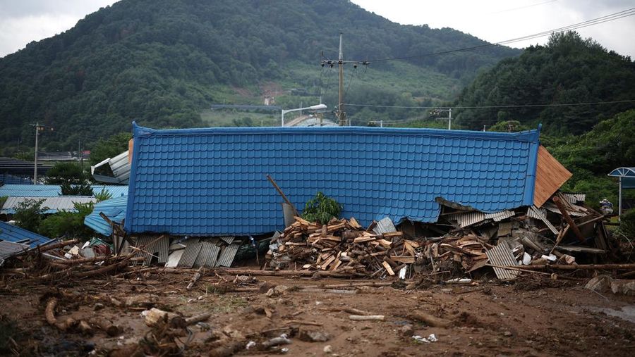 Seorang pria berjalan di depan bangunan yang runtuh akibat hujan deras, di Gapyeong, Korea Selatan, 21 Juli 2025. (REUTERS/Kim Hong-Ji)