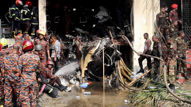 Petugas pemadam kebakaran berupaya membersihkan puing-puing bangunan setelah pesawat latih angkatan udara jatuh di kampus Milestone College, di Dhaka, Bangladesh, 21 Juli 2025. (REUTERS/Stringer)