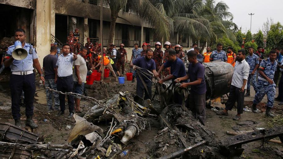 Petugas pemadam kebakaran berupaya membersihkan puing-puing bangunan setelah pesawat latih angkatan udara jatuh di kampus Milestone College, di Dhaka, Bangladesh, 21 Juli 2025. (REUTERS/Stringer)