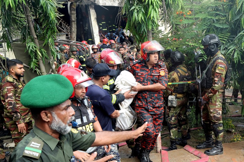 Petugas pemadam kebakaran berupaya membersihkan puing-puing bangunan setelah pesawat latih angkatan udara jatuh di kampus Milestone College, di Dhaka, Bangladesh, 21 Juli 2025. (REUTERS/Stringer)