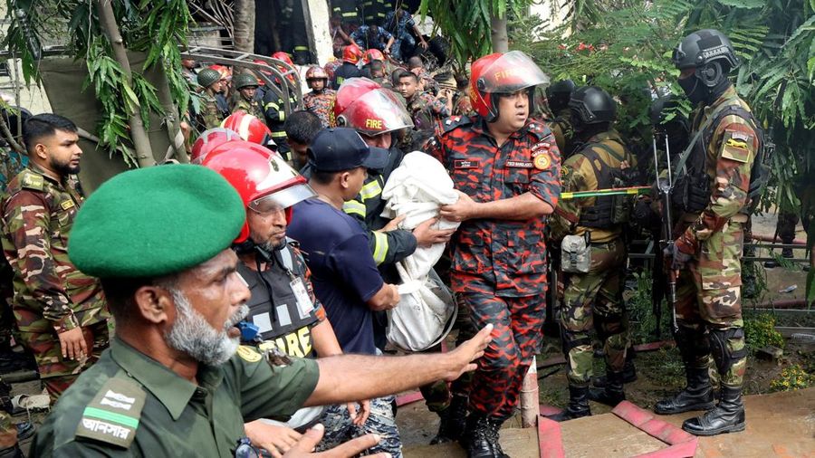 Petugas pemadam kebakaran berupaya membersihkan puing-puing bangunan setelah pesawat latih angkatan udara jatuh di kampus Milestone College, di Dhaka, Bangladesh, 21 Juli 2025. (REUTERS/Stringer)