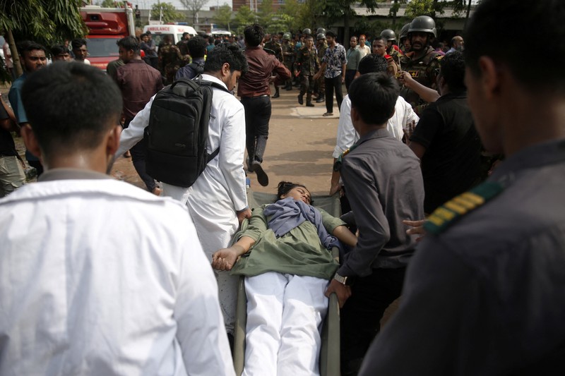Petugas pemadam kebakaran berupaya membersihkan puing-puing bangunan setelah pesawat latih angkatan udara jatuh di kampus Milestone College, di Dhaka, Bangladesh, 21 Juli 2025. (REUTERS/Stringer)