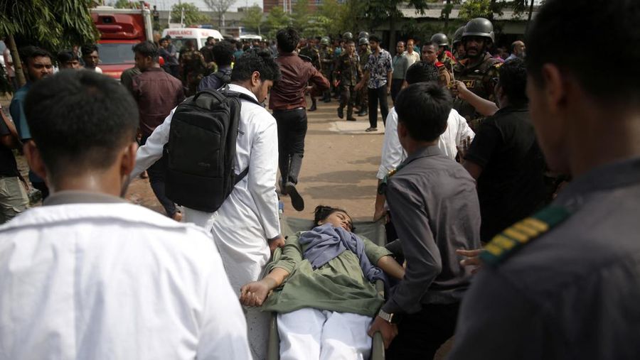 Petugas pemadam kebakaran berupaya membersihkan puing-puing bangunan setelah pesawat latih angkatan udara jatuh di kampus Milestone College, di Dhaka, Bangladesh, 21 Juli 2025. (REUTERS/Stringer)