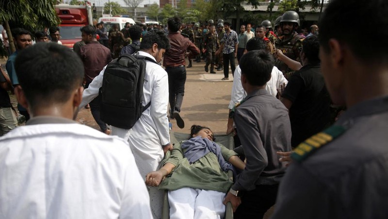 Petugas pemadam kebakaran berupaya membersihkan puing-puing bangunan setelah pesawat latih angkatan udara jatuh di kampus Milestone College, di Dhaka, Bangladesh, 21 Juli 2025. (REUTERS/Stringer)