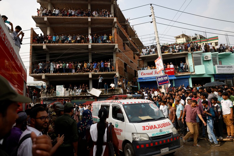 Petugas pemadam kebakaran berupaya membersihkan puing-puing bangunan setelah pesawat latih angkatan udara jatuh di kampus Milestone College, di Dhaka, Bangladesh, 21 Juli 2025. (REUTERS/Stringer)