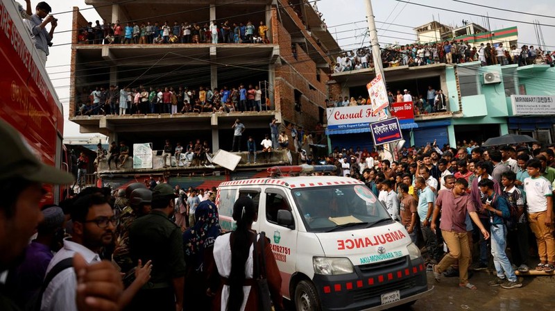 Petugas pemadam kebakaran berupaya membersihkan puing-puing bangunan setelah pesawat latih angkatan udara jatuh di kampus Milestone College, di Dhaka, Bangladesh, 21 Juli 2025. (REUTERS/Stringer)