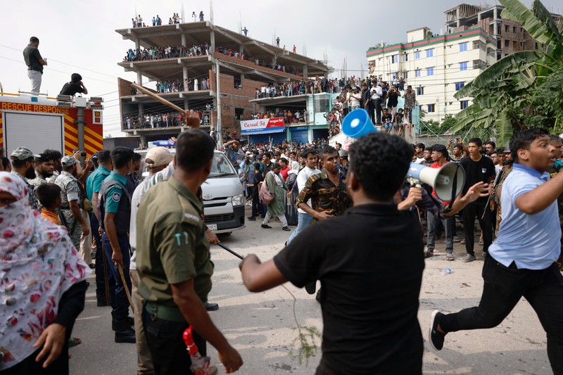 Petugas pemadam kebakaran berupaya membersihkan puing-puing bangunan setelah pesawat latih angkatan udara jatuh di kampus Milestone College, di Dhaka, Bangladesh, 21 Juli 2025. (REUTERS/Stringer)