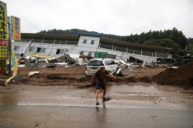 Seorang pria berjalan di depan bangunan yang runtuh akibat hujan deras, di Gapyeong, Korea Selatan, 21 Juli 2025. (REUTERS/Kim Hong-Ji)
