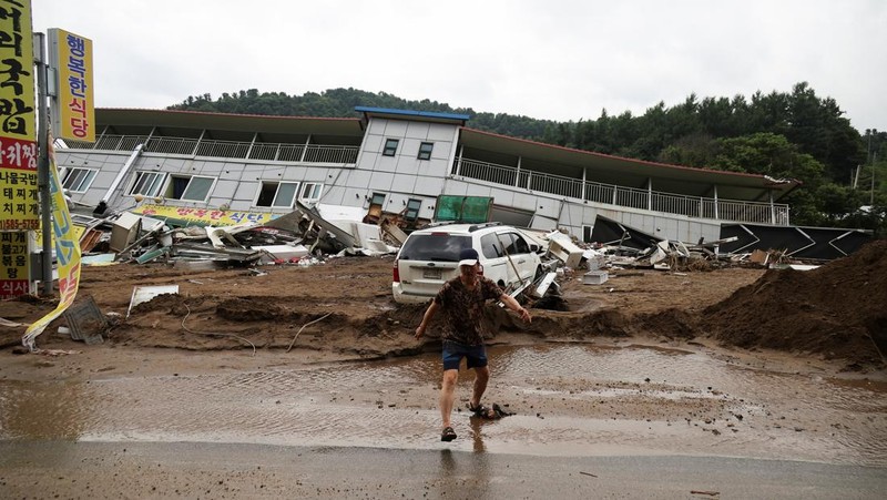 Seorang pria berjalan di depan bangunan yang runtuh akibat hujan deras, di Gapyeong, Korea Selatan, 21 Juli 2025. (REUTERS/Kim Hong-Ji)