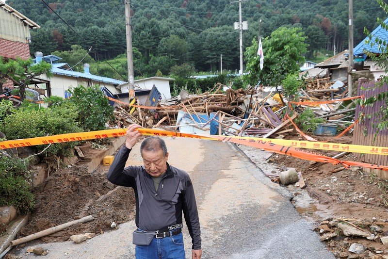 Seorang pria berjalan di depan bangunan yang runtuh akibat hujan deras, di Gapyeong, Korea Selatan, 21 Juli 2025. (REUTERS/Kim Hong-Ji)