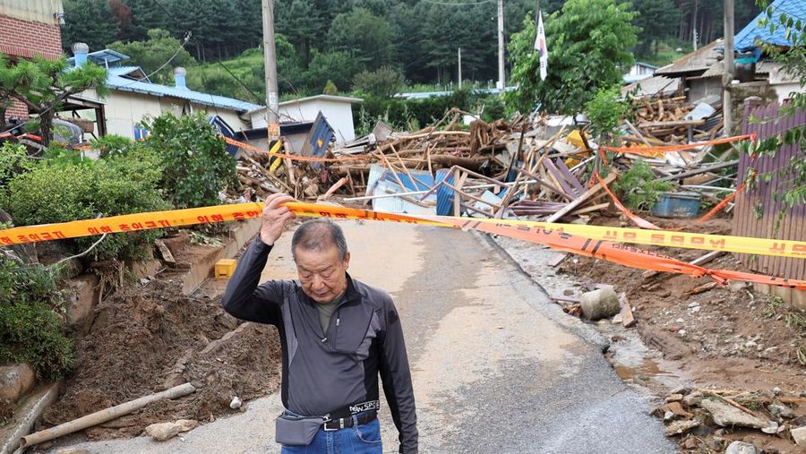 Seorang pria berjalan di depan bangunan yang runtuh akibat hujan deras, di Gapyeong, Korea Selatan, 21 Juli 2025. (REUTERS/Kim Hong-Ji)