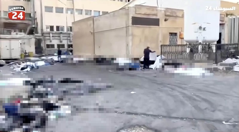 Rekaman video memperlihatkan kantong-kantong jenazah berserakan di halaman Rumah Sakit Nasional Sweida, yang dihuni mayoritas warga komunitas Druze, di kota Sweida, Suriah selatan, pada Minggu (20/7). (Tangkapan Layar Video Reuters/Suwayda 24)