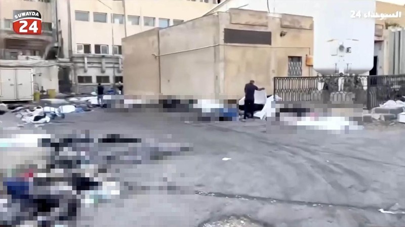 Rekaman video memperlihatkan kantong-kantong jenazah berserakan di halaman Rumah Sakit Nasional Sweida, yang dihuni mayoritas warga komunitas Druze, di kota Sweida, Suriah selatan, pada Minggu (20/7). (Tangkapan Layar Video Reuters/Suwayda 24)