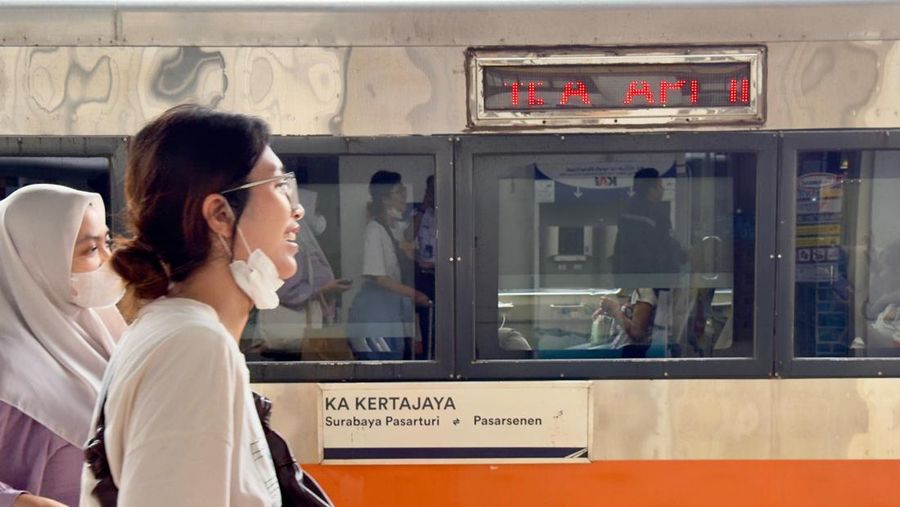 Seorang penumpang berjalan di depan rangkaian Kereta Api Kertajaya. (Dok. KAI)