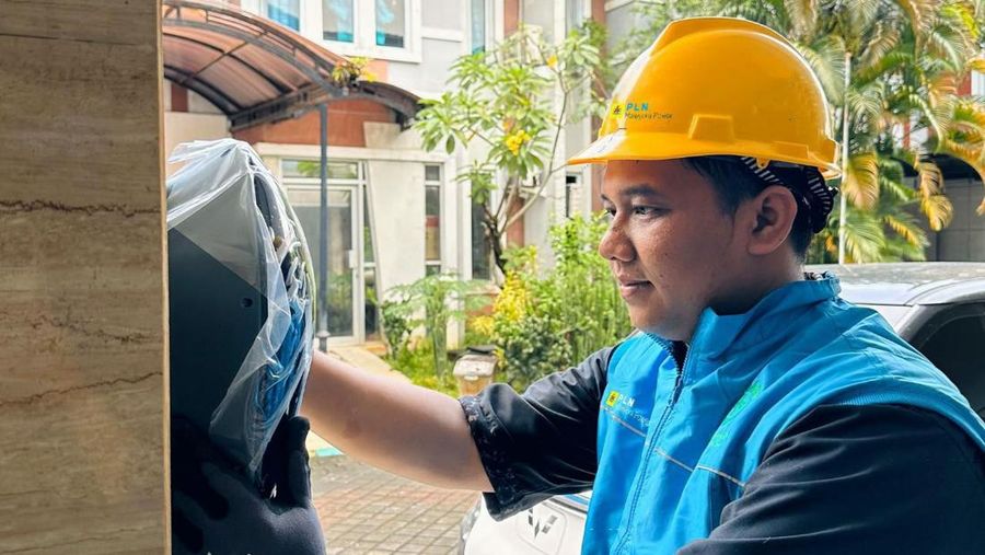 Ilustrasi petugas PLN saat melakukan pemasangan charger di rumah pelanggan untuk memudahkan pengisian kendaraan listrik di rumah melalui layanan Home Charging Services. (Dok. PT PLN (Persero))